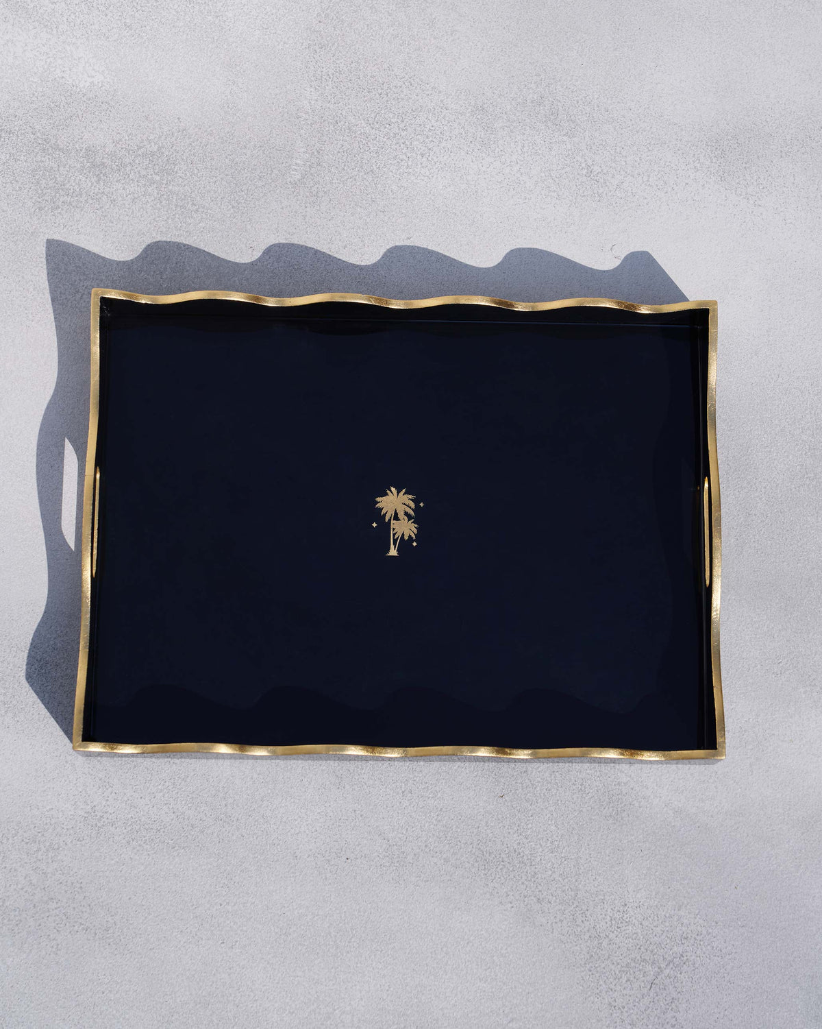 Twilight Tray in black seen from above with a small gold palm tree at its centre.