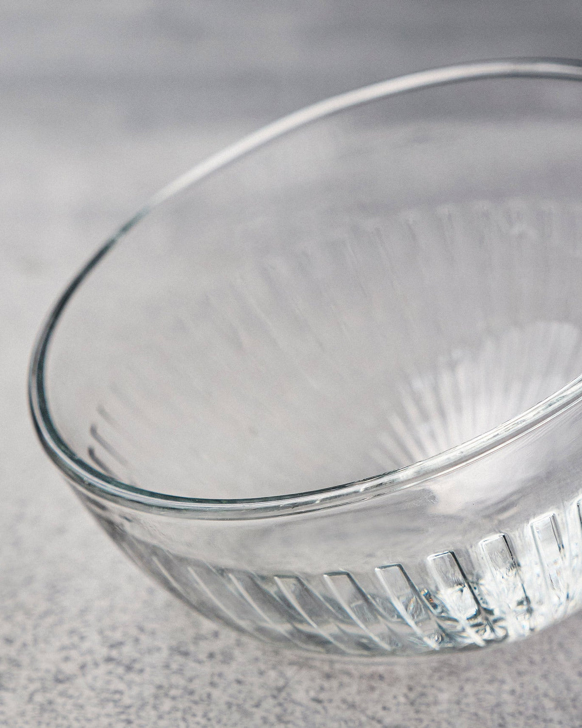 Close-up of a clear Mahi nut bowl showing vertical fluting near the base.