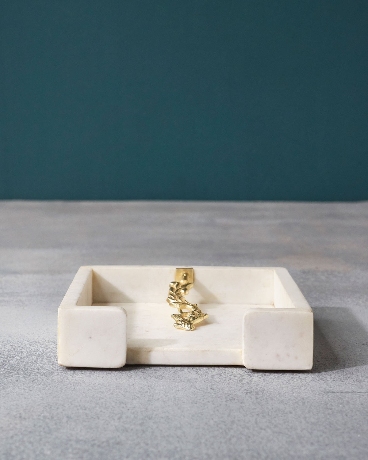 Mahi Napkin Holder with its gold fish-motif upright at the centre.