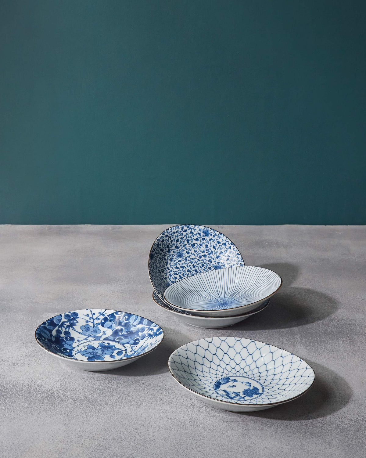 Donburi shallow bowls showing floral, lattice, speckled, and radial blue designs.