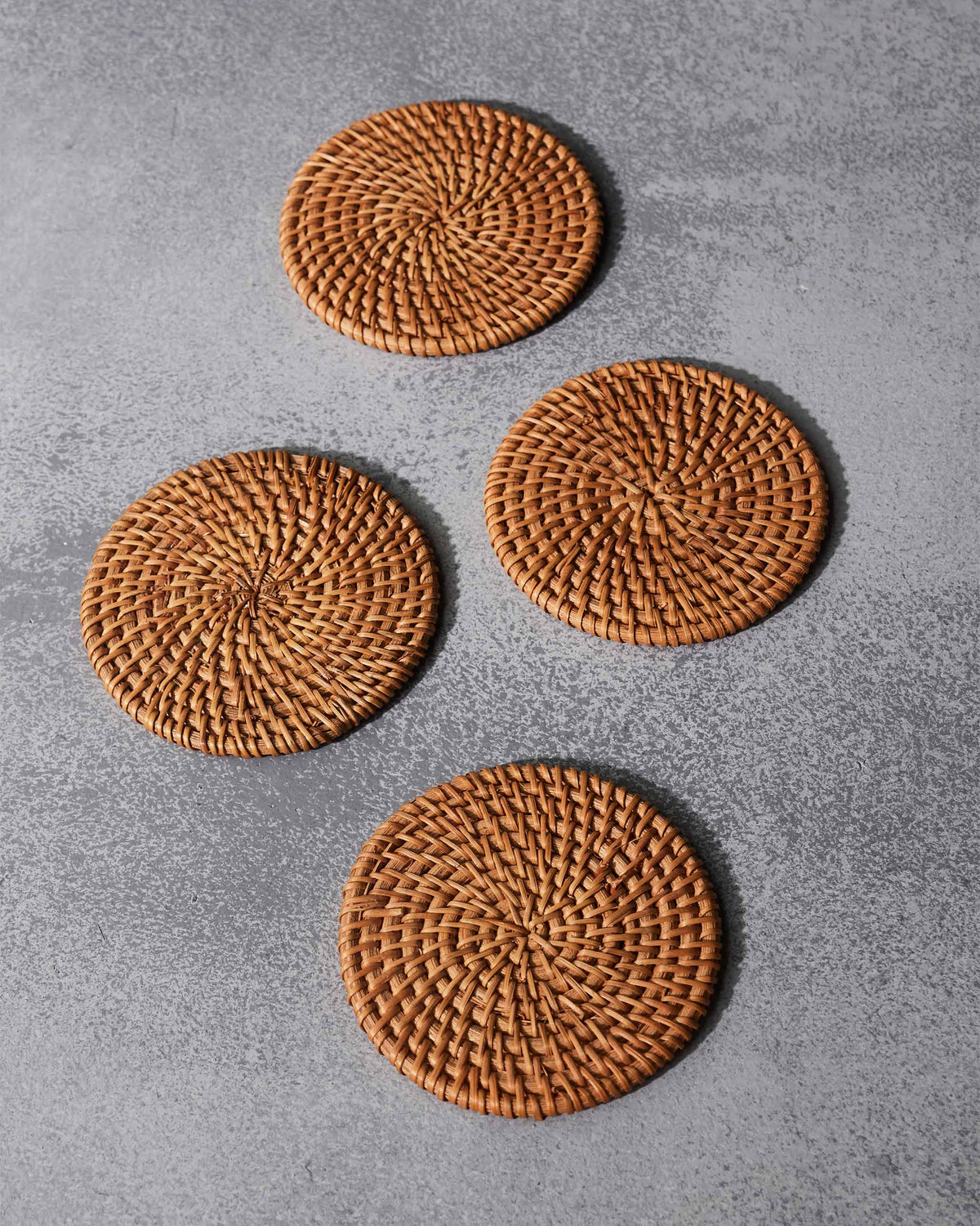 Overhead view of four Rattan Coasters in a loose group.