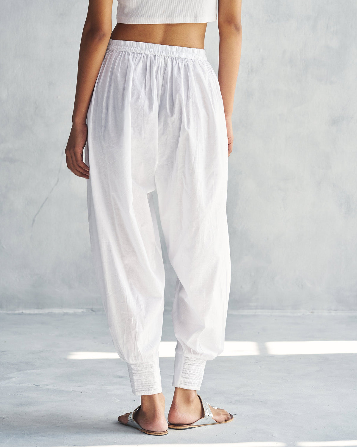 Back of white Puff Pants with an elastic waist, worn by a person.