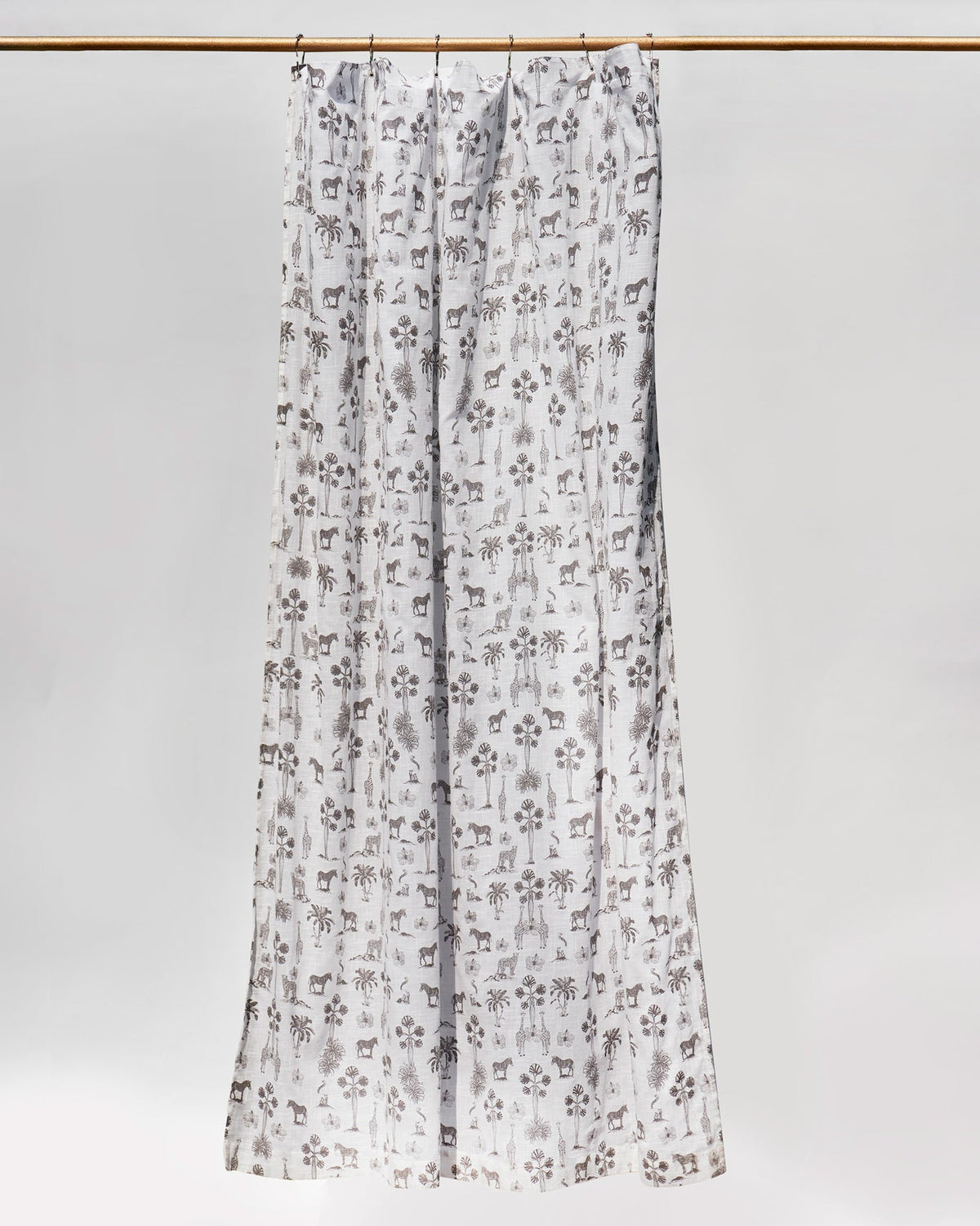 Full-length Twilight Shower Curtain hanging from a rail in its grey animal print.
