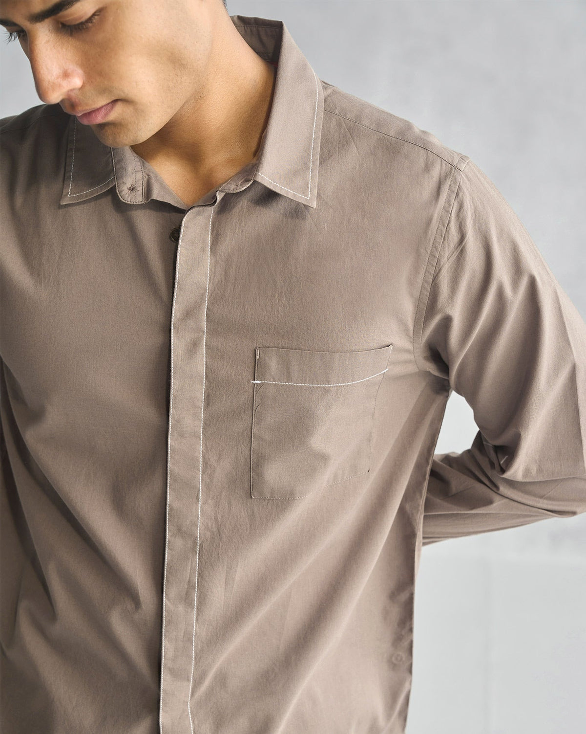 Close-up of an oak brown Plateau shirt showing its chest pocket and white topstitching.