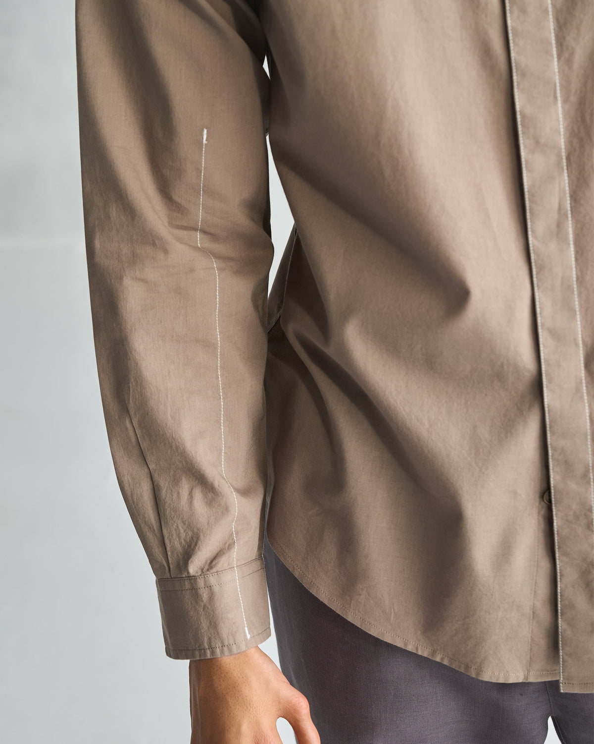 Close-up of an oak brown Plateau shirt sleeve with white topstitching down the arm.