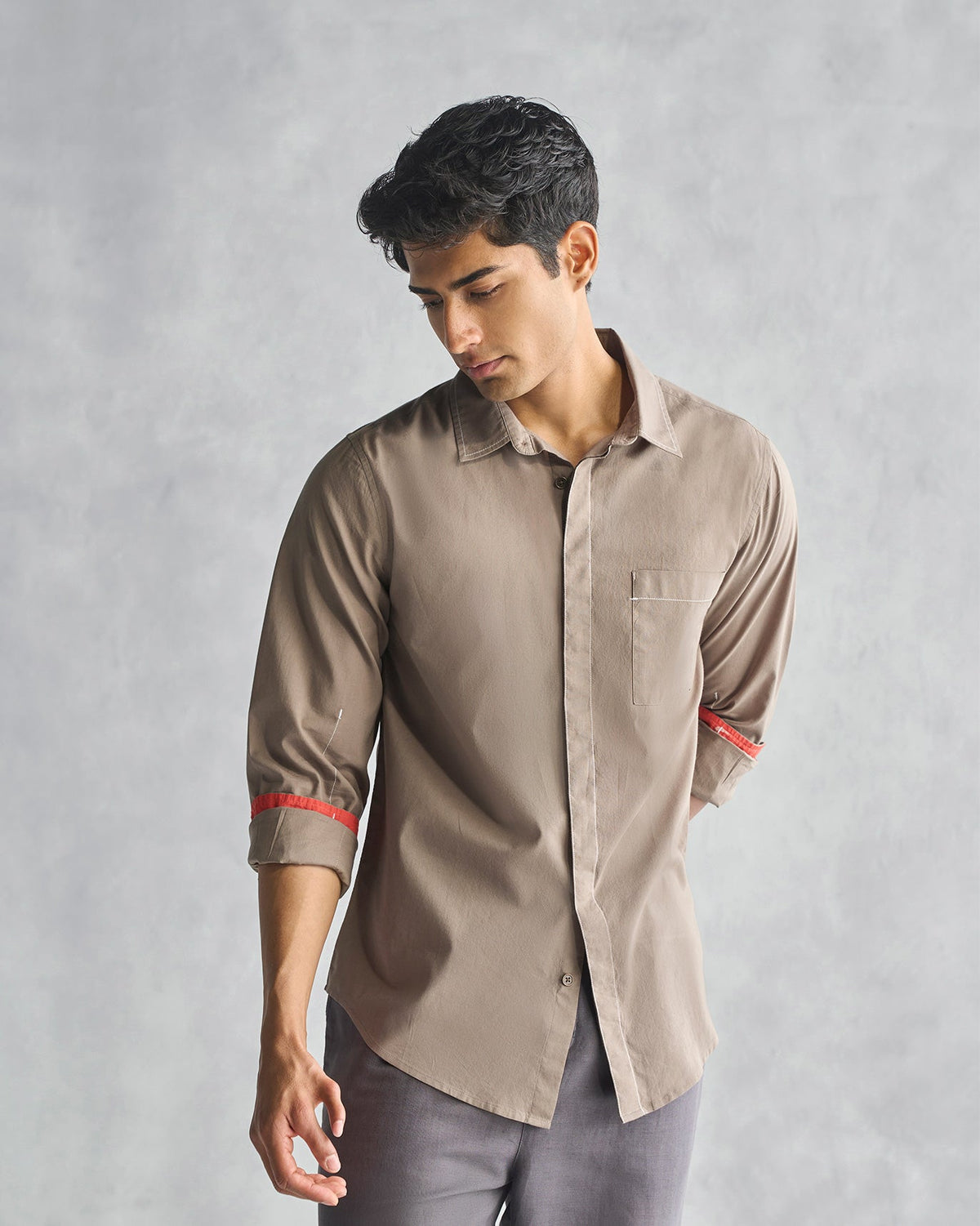 Person wearing an oak brown Plateau shirt with red-lined cuffs turned up.