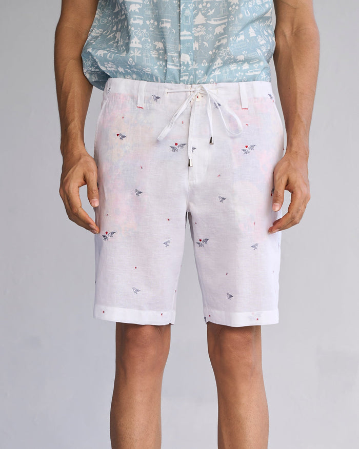 Person wearing white Jambo Shorts with small embroidered birds.