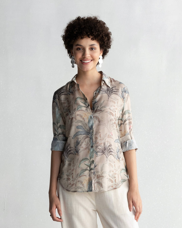 Person wearing a Tropico Shirt with a palm leaf print.