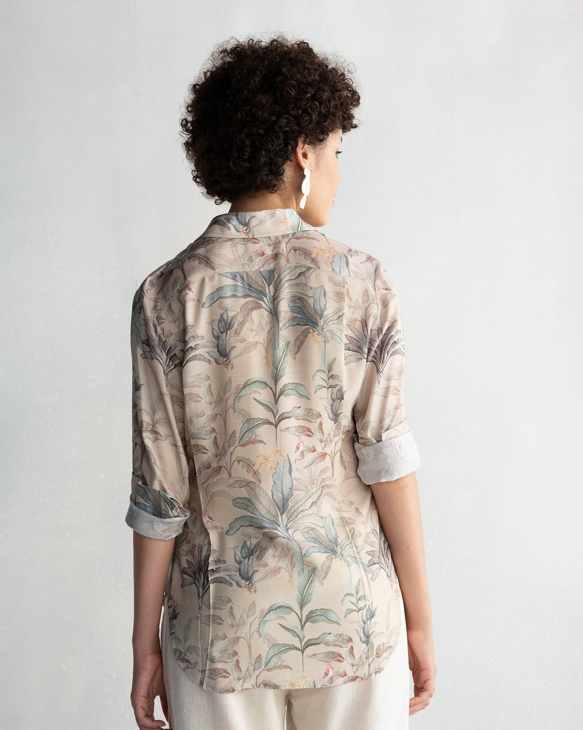Back of a Tropico Shirt with palm leaf print worn by a person.