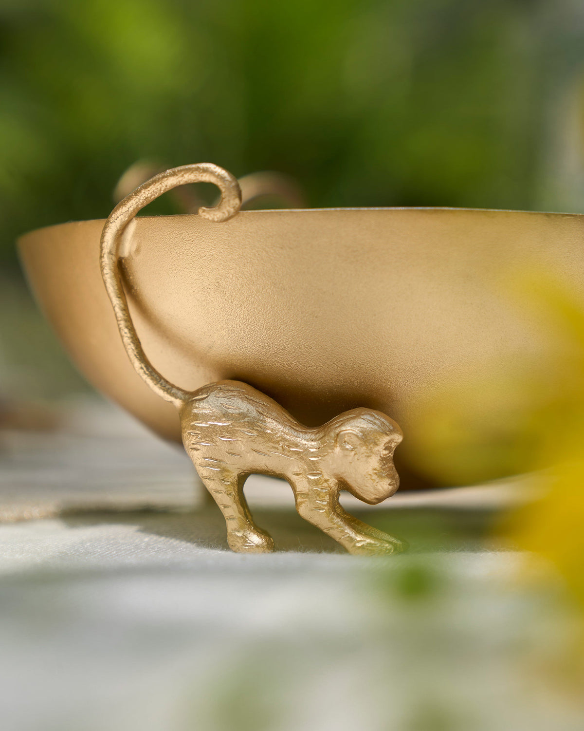 Brolly Deco Bowl with a gold monkey figure at its rim.