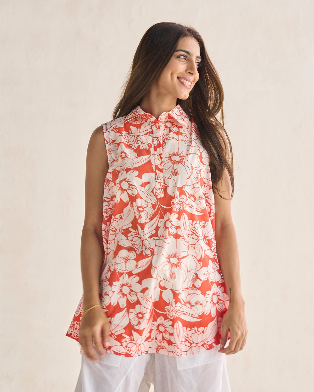 Person wearing an ivory and coral Susadei Shirt with a floral print.