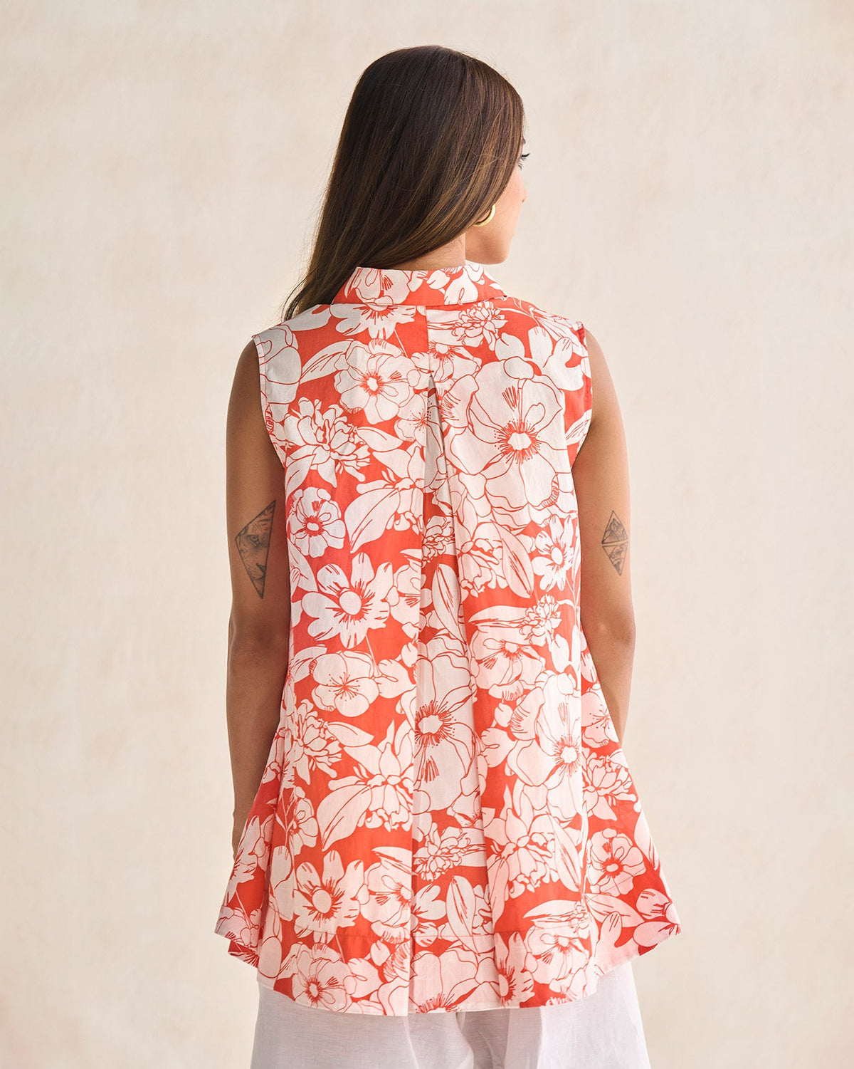Back of a Susadei Shirt with a coral floral print, worn by a person.