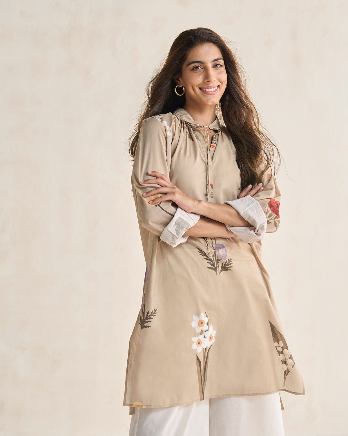 Person wearing a beige Boribo Highland kurta with embroidered flowers at the hem.