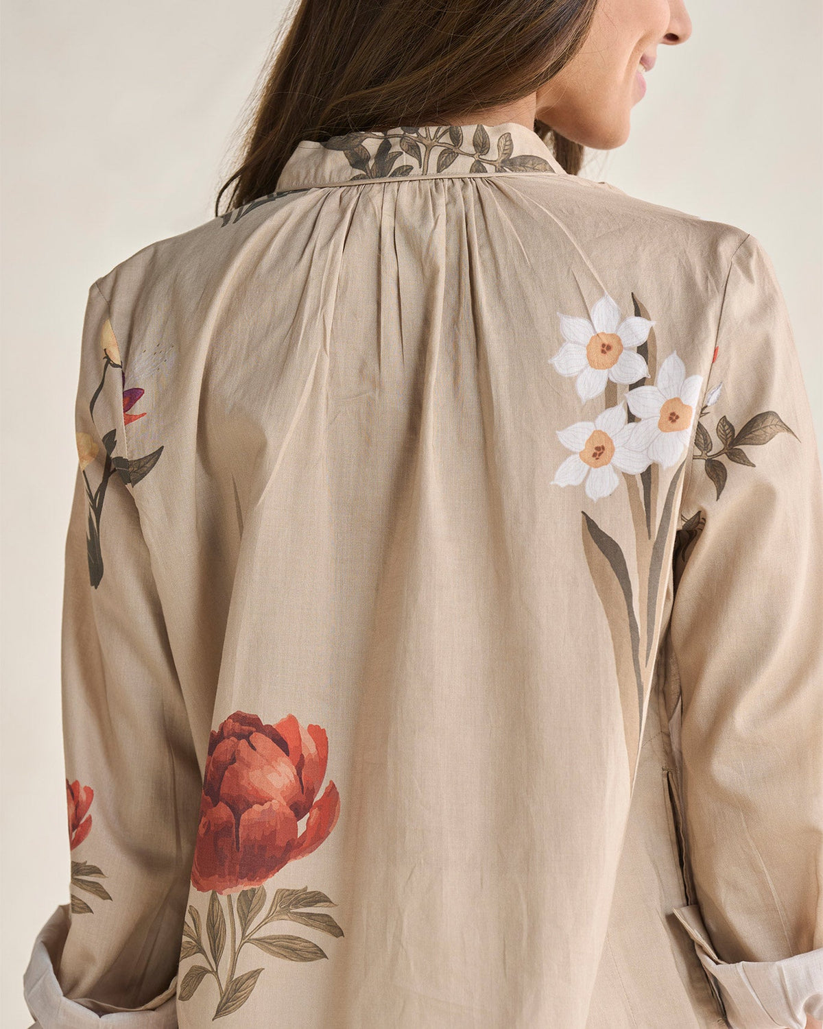 Close-up of the shoulder of a beige Boribo Highland kurta with peony and daffodil motifs.