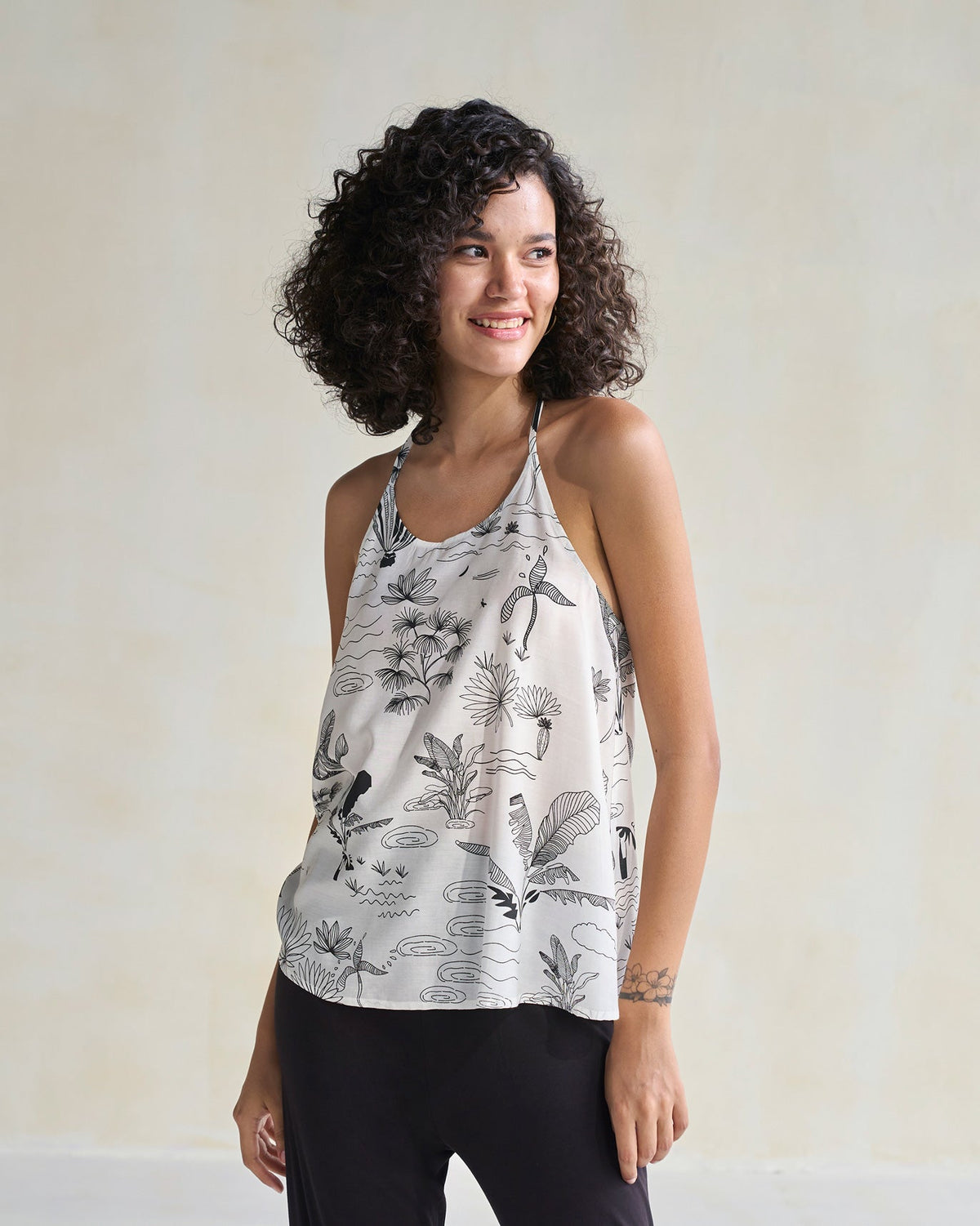 Front view of an ivory Tranquila Camisole worn by a person.