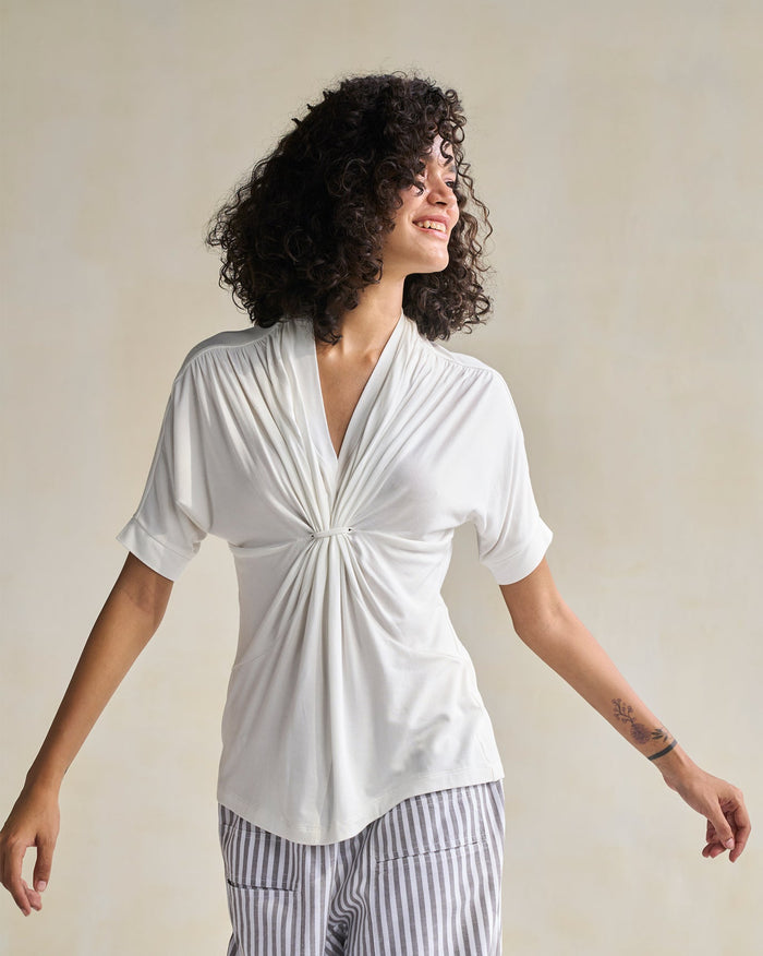 Person wearing an ivory Gathered Jersey Top with a knotted V-neck.