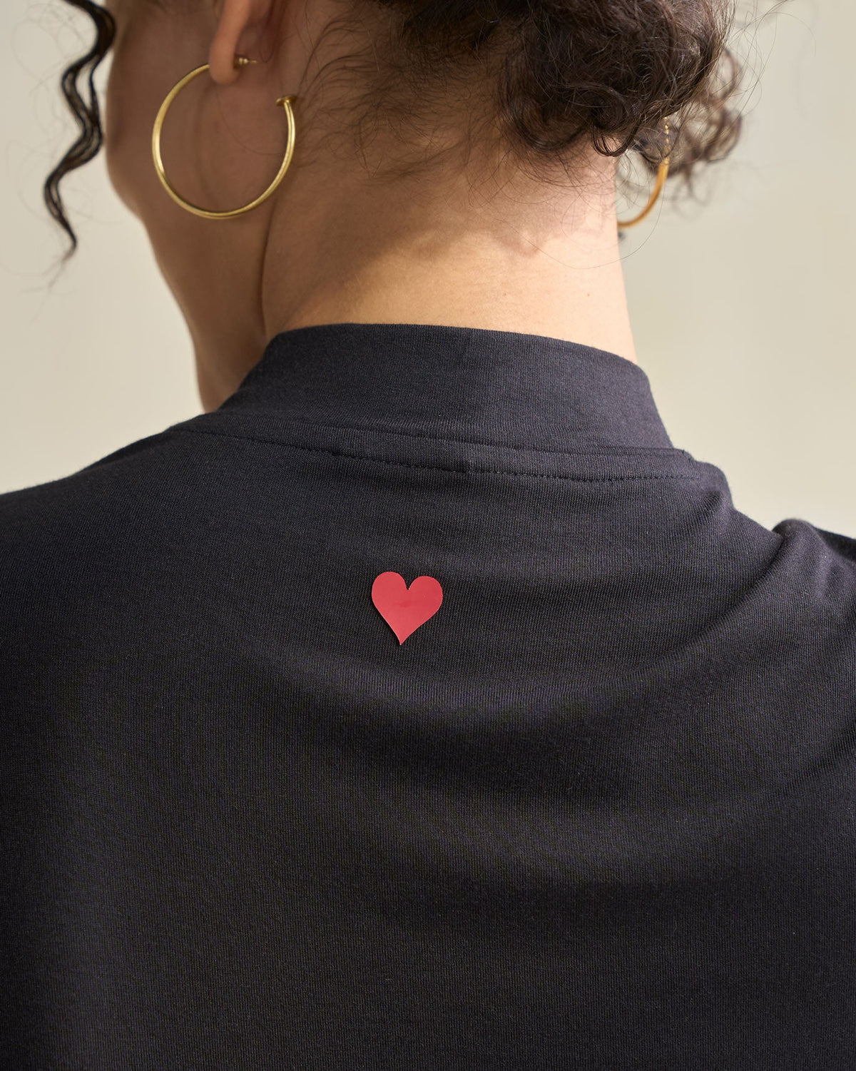 Close-up of a black Gathered Jersey Top showing a small red heart at the back neck.