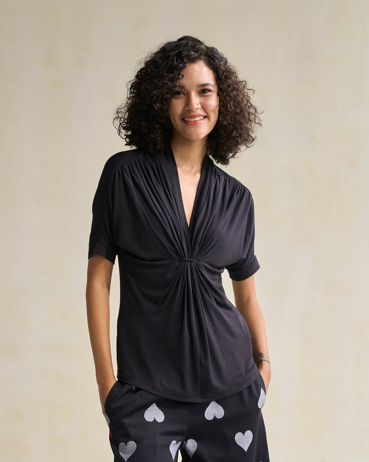 Person standing in a black Gathered Jersey Top with a knotted waist.