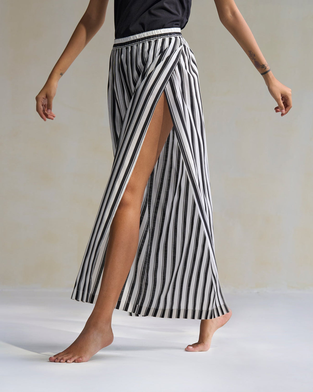 Side view of black and ivory Celeste Pyjamas with a front slit.