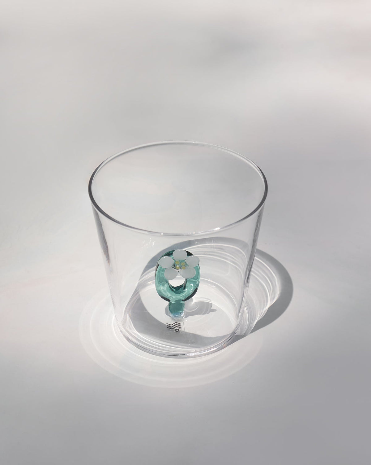 Clear Alphabet glass showing a teal letter O with a white flower at the base.