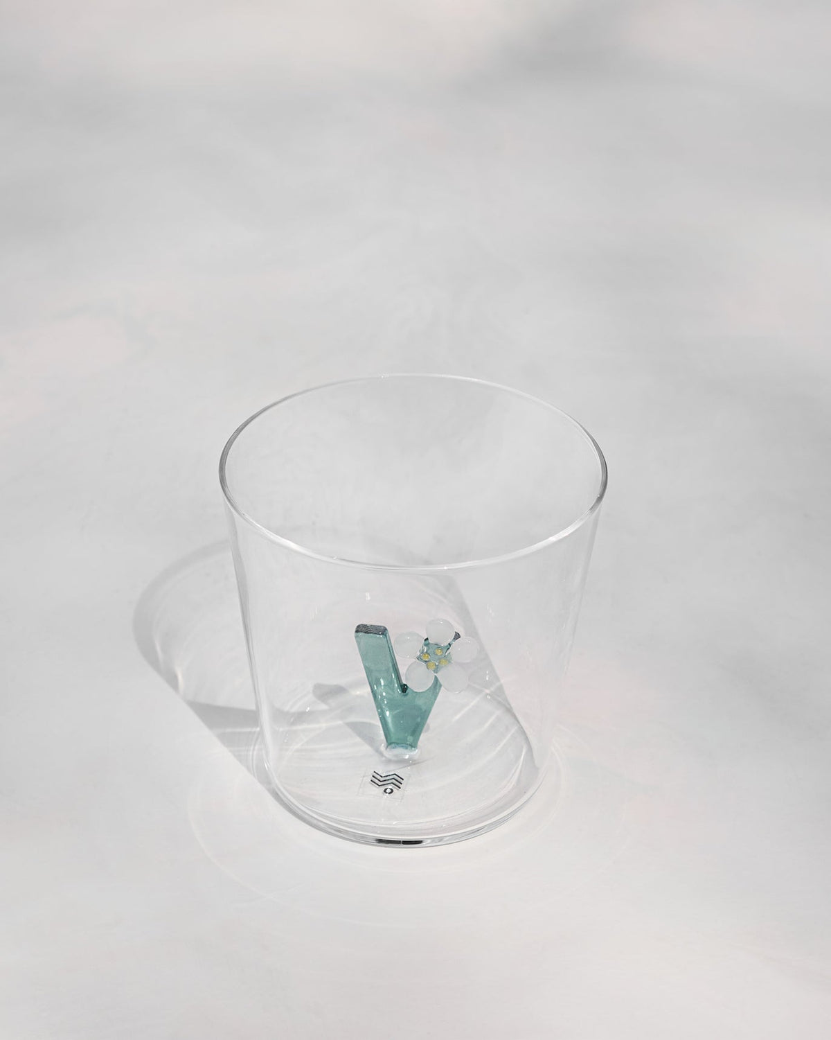 Clear Alphabet glass showing a teal letter V with a white flower at the base.