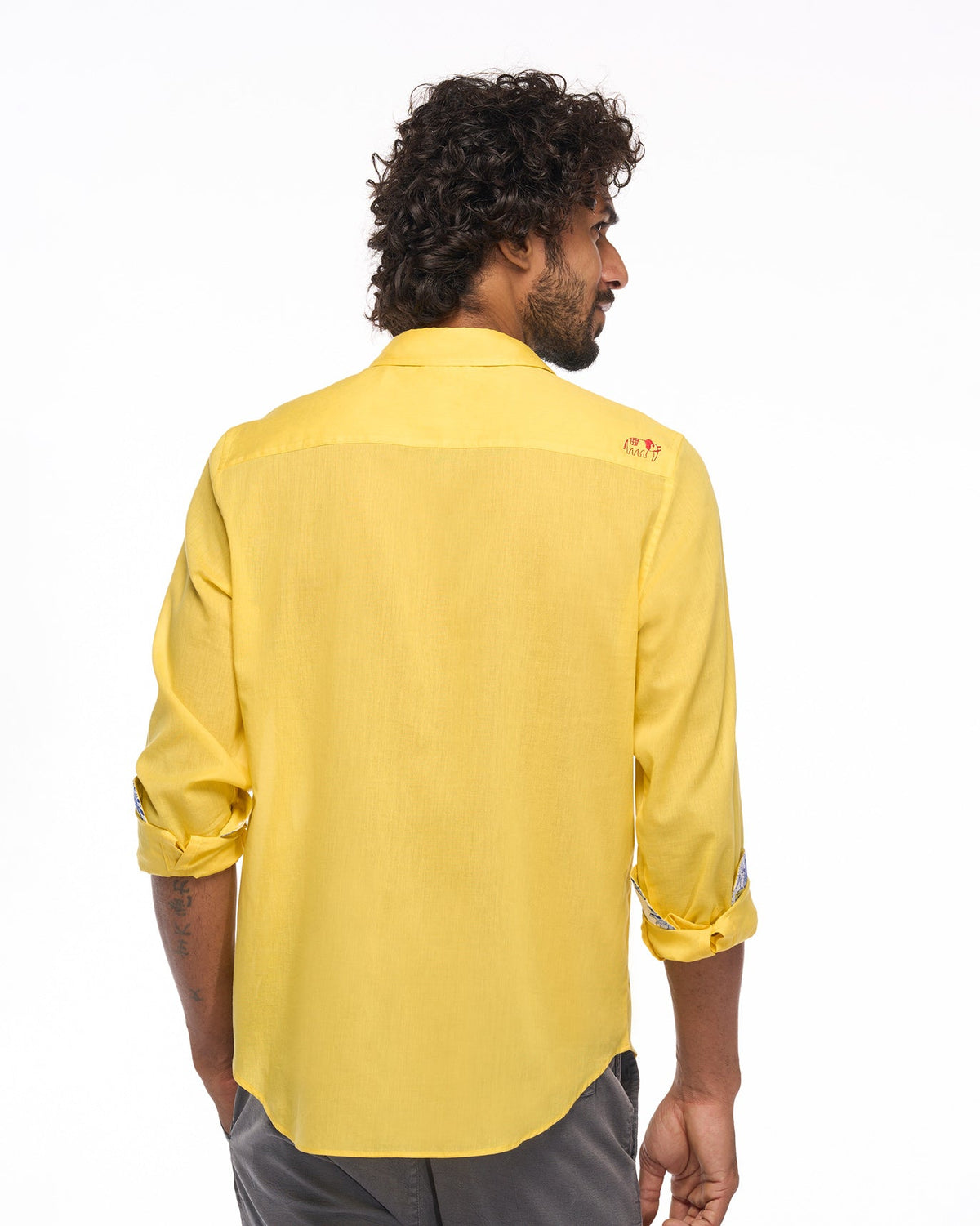 Back of a yellow Sankara shirt worn by a person.