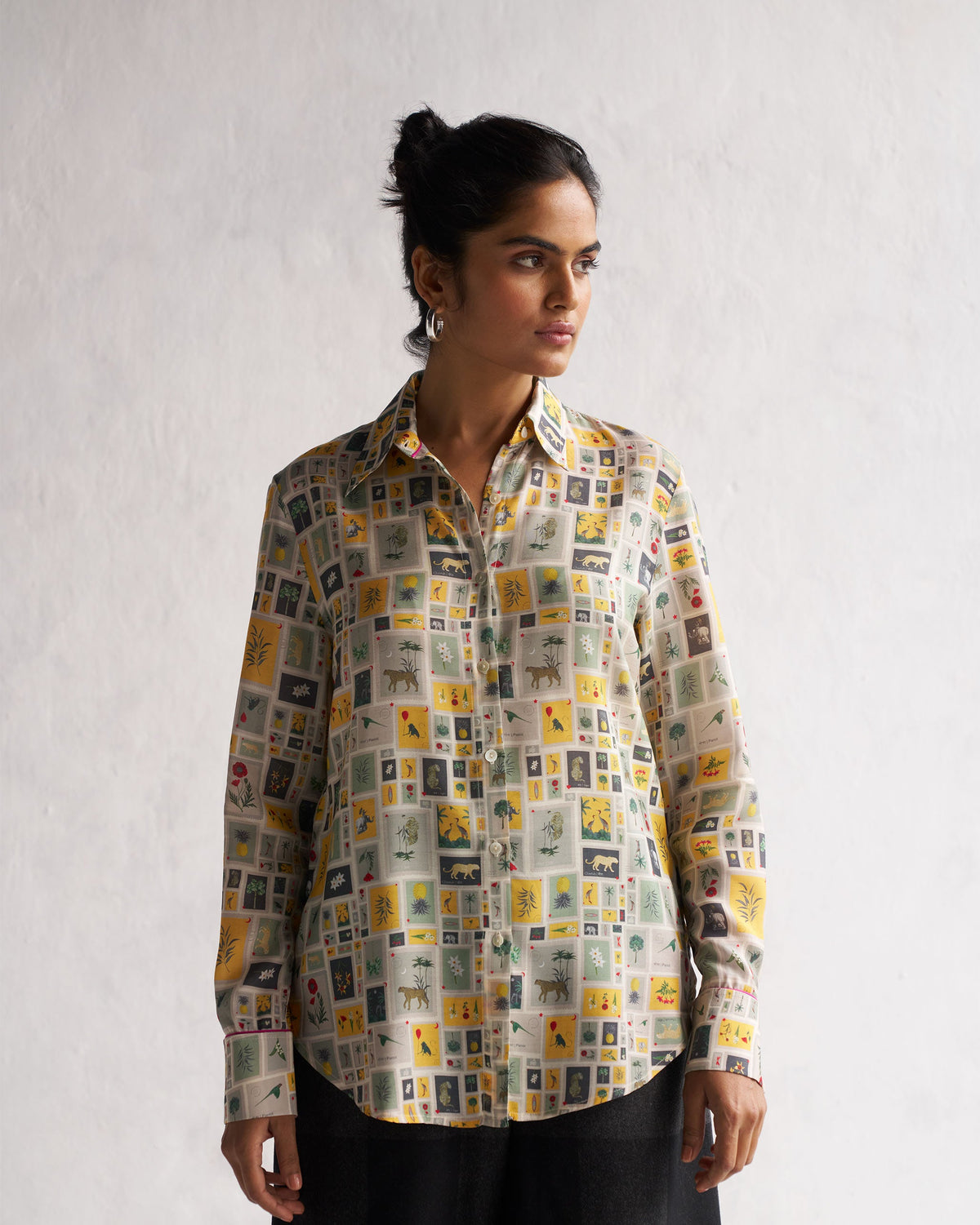 Person wearing a Basic Shirt in a multicolour print of framed animal and plant tiles.