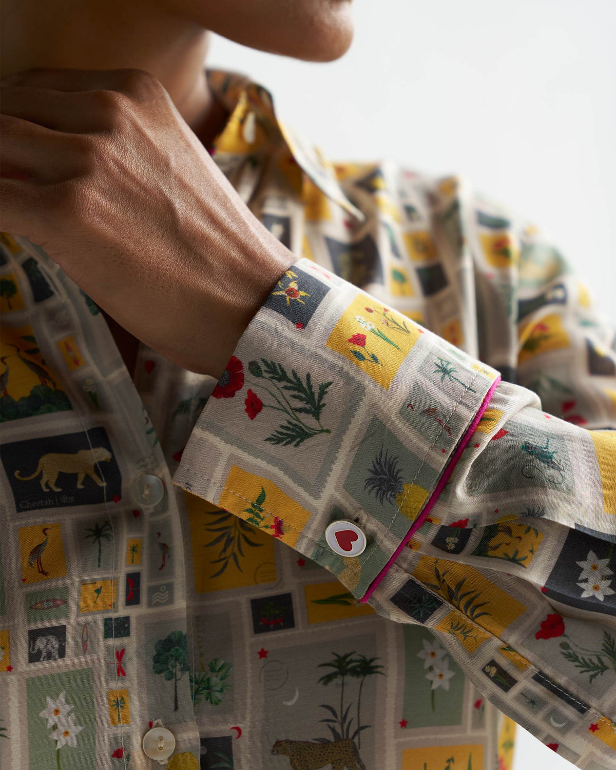 Close-up of a Basic Shirt cuff in the tile print, with a red heart button.