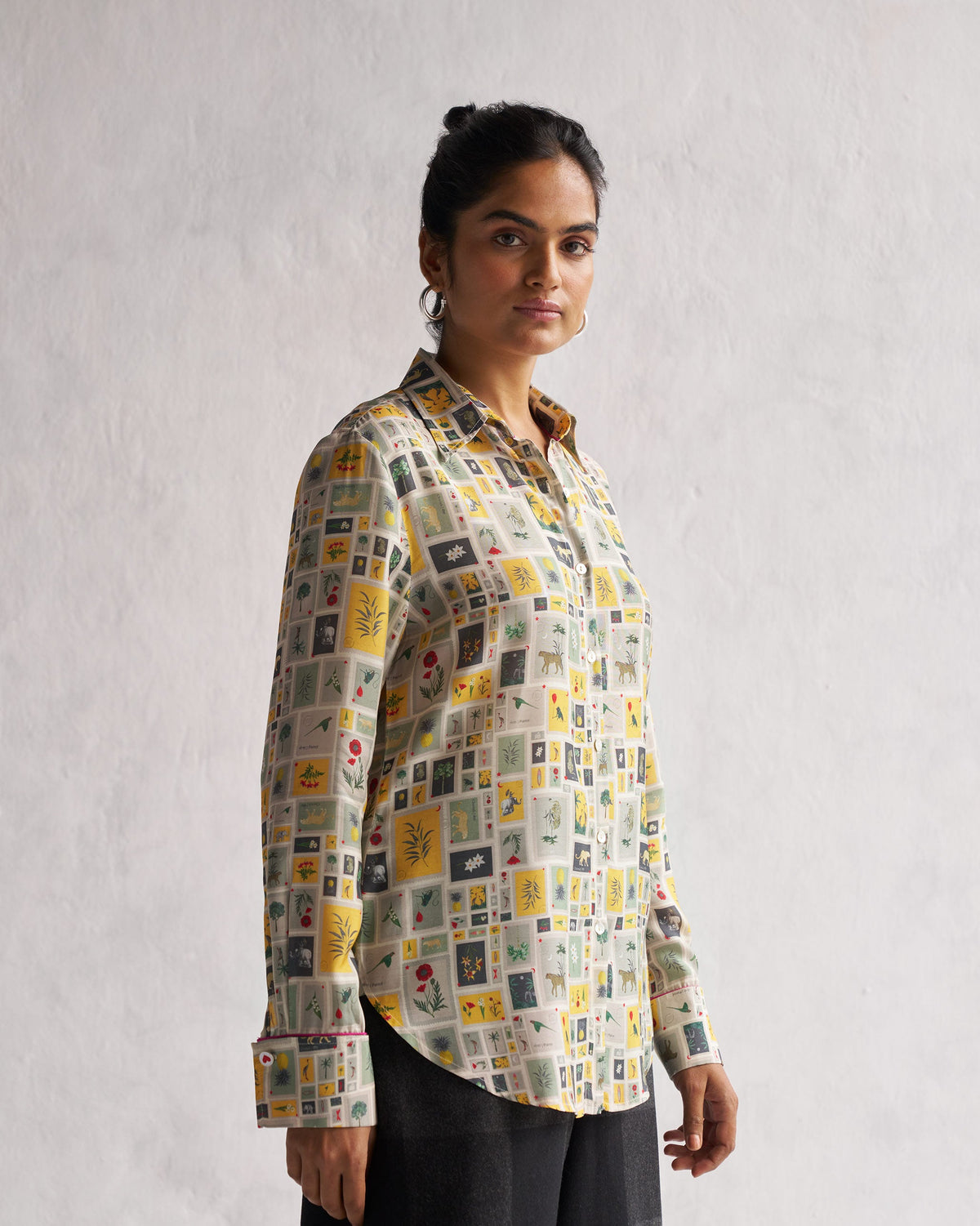 Person wearing a Basic Shirt with a tile print, turned to the side.