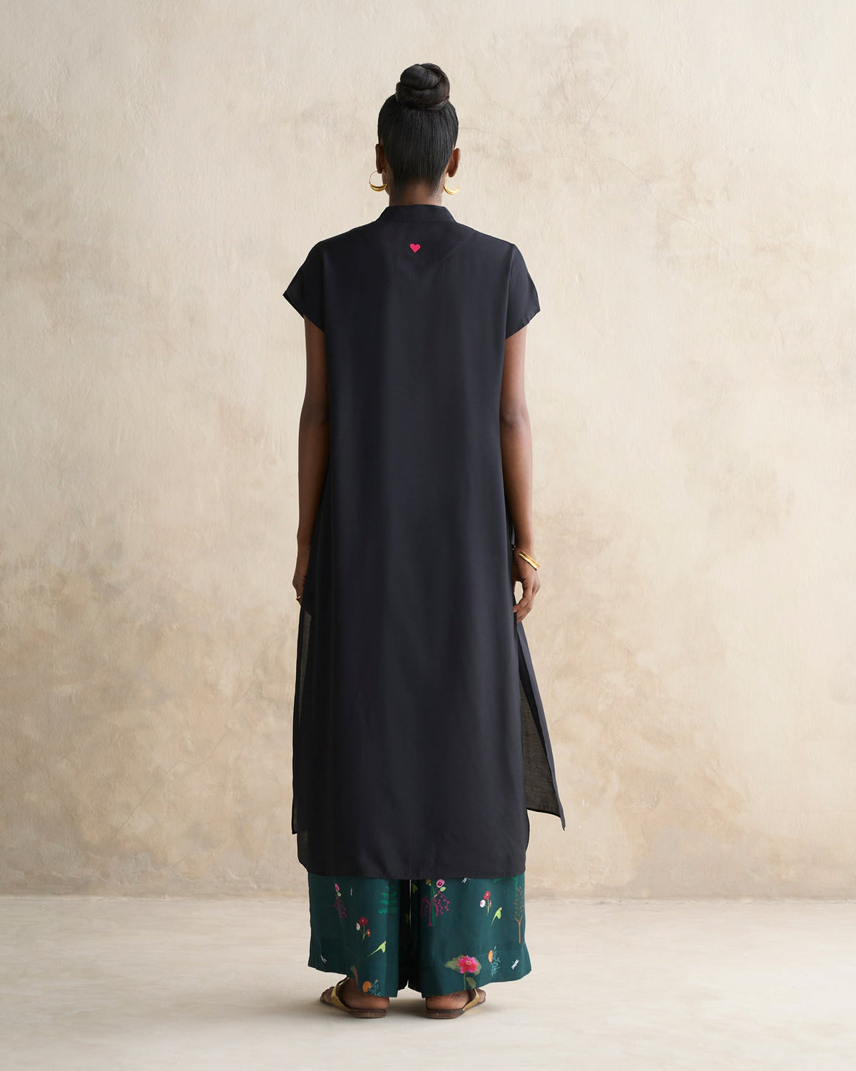 Back of a black Short Sleeve Kurta worn by a person, showing its side slits.