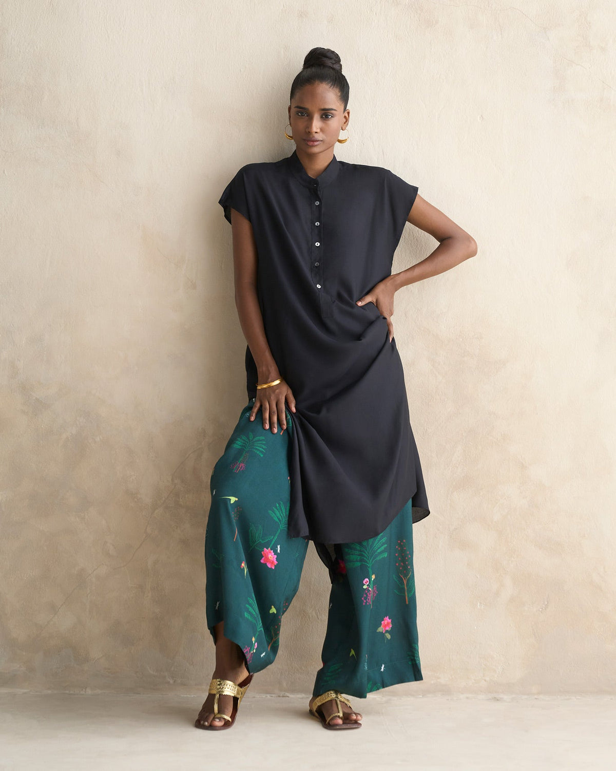Person wearing a long black Short Sleeve Kurta with side slits.