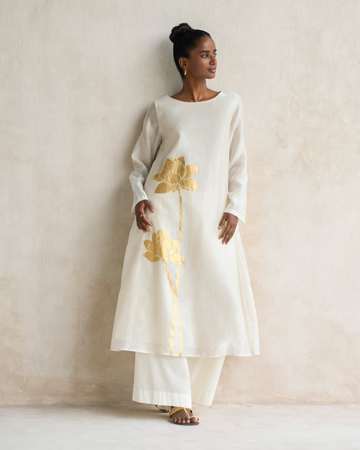 Person wearing ivory Boat Neck Kurta with gold lotus motifs.