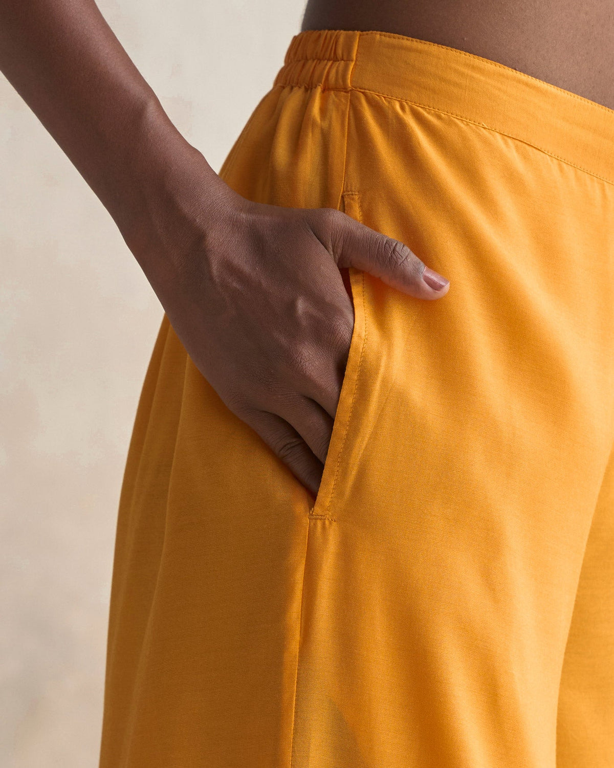 Close-up of tangerine Basic Pyjamas showing a side pocket.