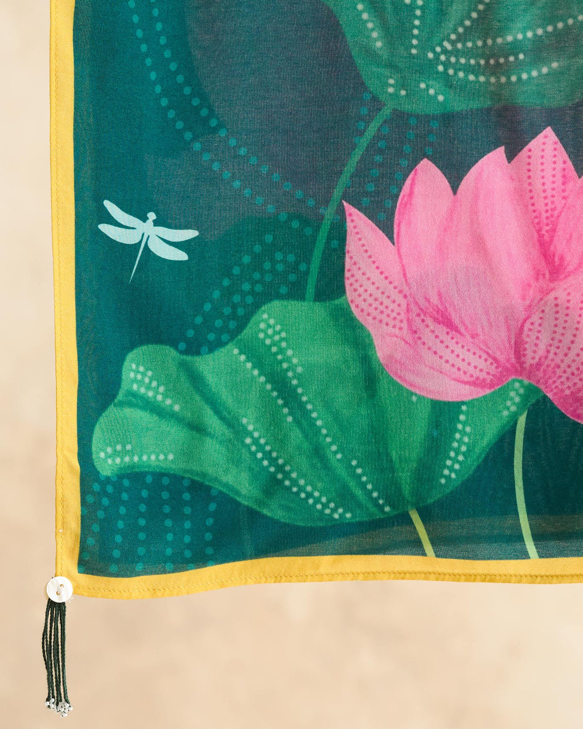 Close-up of a corner of the green Lotus scarf showing a pink lotus and dragonfly.