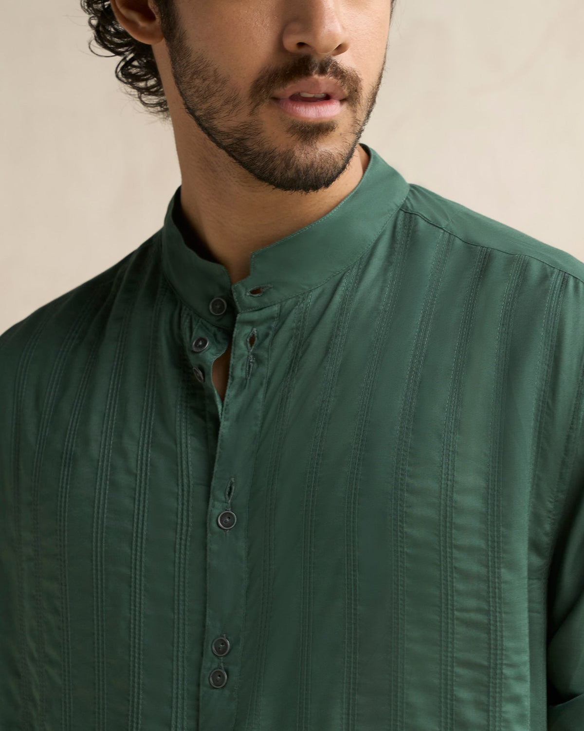 Close-up of a deep green Long Pleated Kurta showing the band collar and vertical pleats.