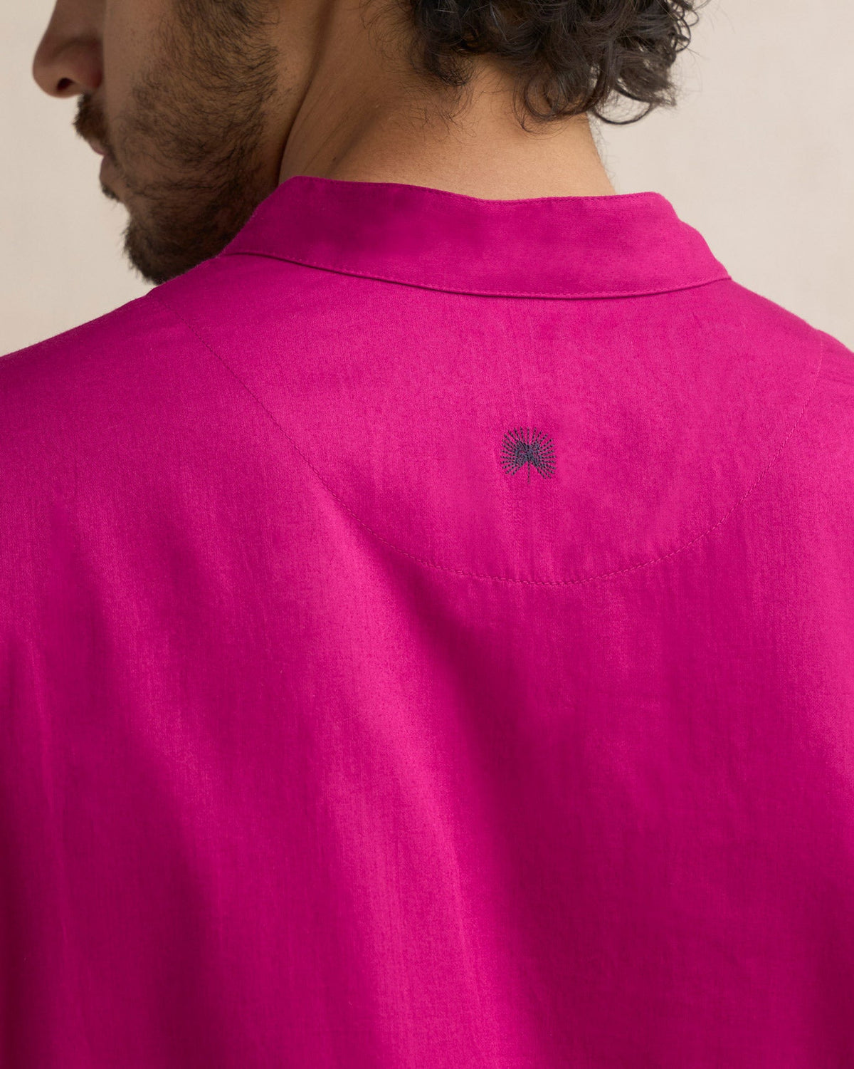 Close-up of the back neck of a deep pink Long Pleated Kurta showing a small dark embroidered motif.