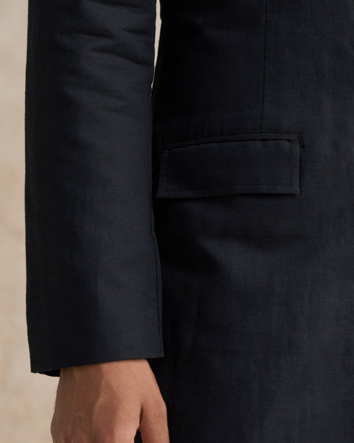 Close-up of a black Negombo bandhgala showing a flap pocket.