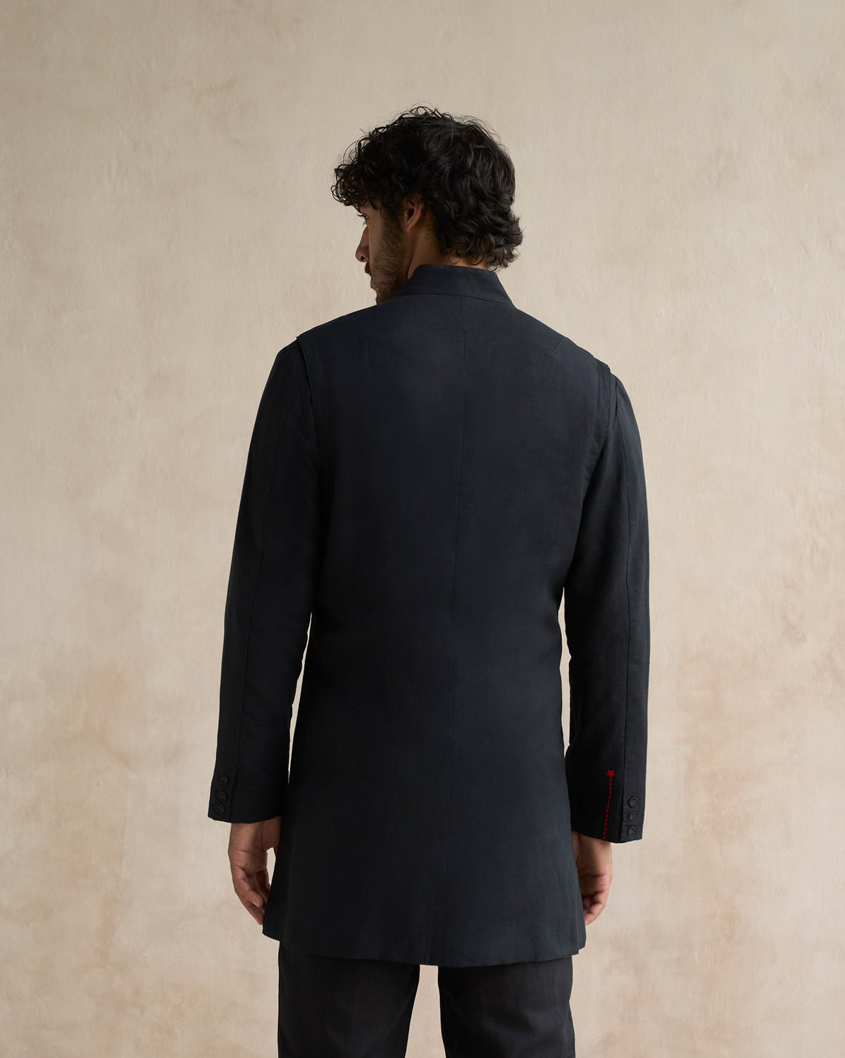 Back of a black Negombo bandhgala worn by a person.