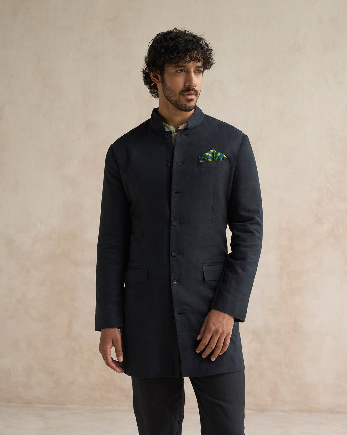 Person wearing a black Negombo bandhgala with flap pockets.