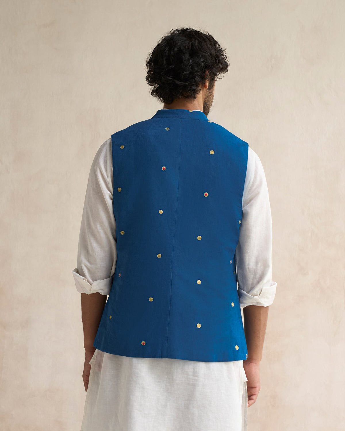 Back of a sapphire Nehru jacket worn by a person.