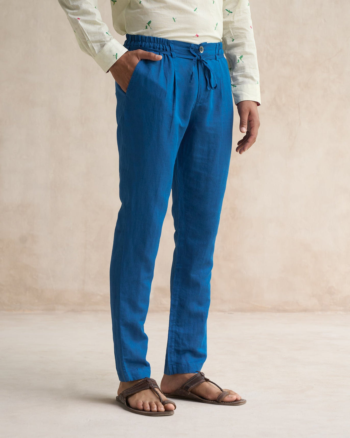 Person wearing sapphire Banjara Trousers with one hand in the pocket.