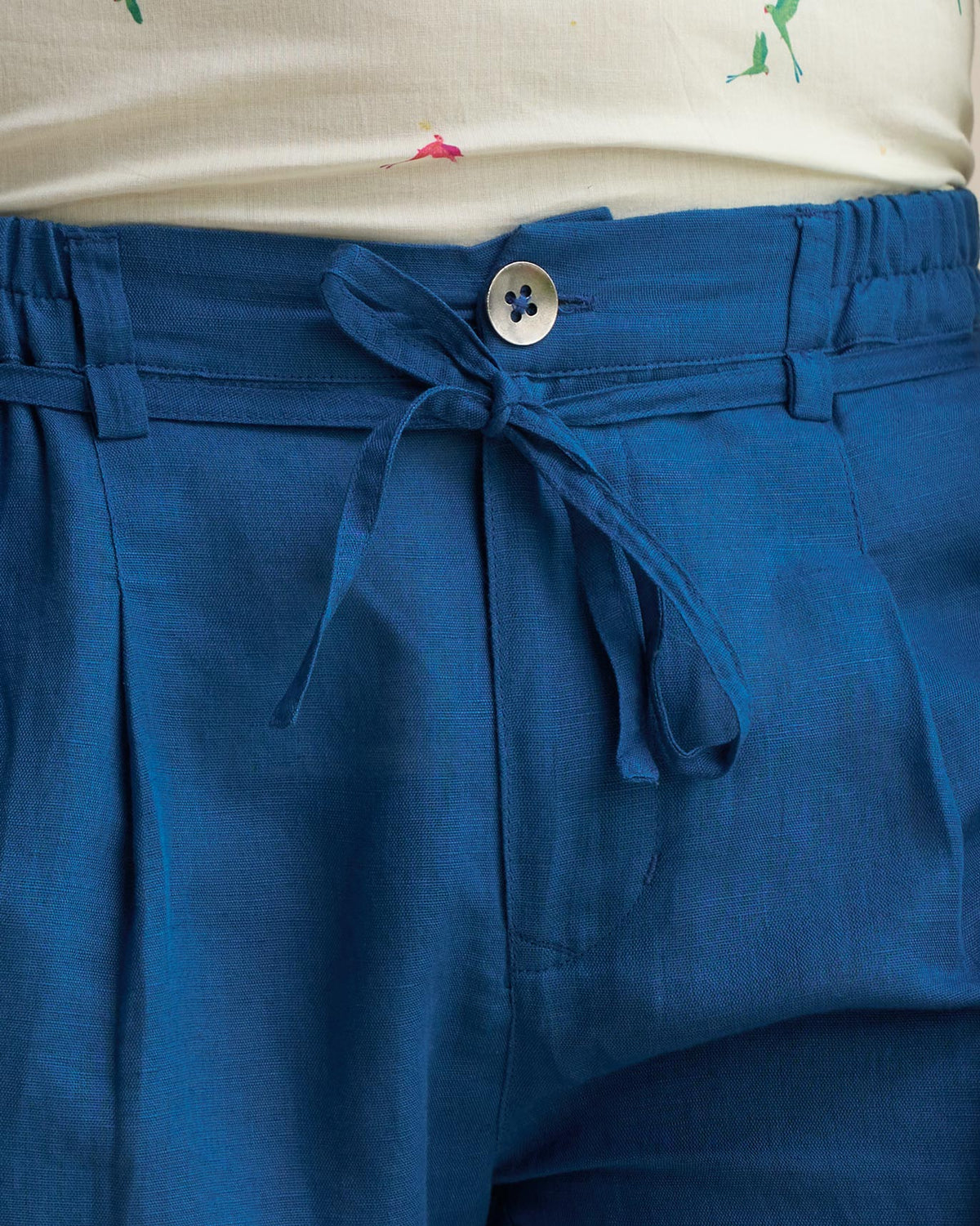 Close-up of the sapphire Banjara Trousers showing the button and drawstring waist.