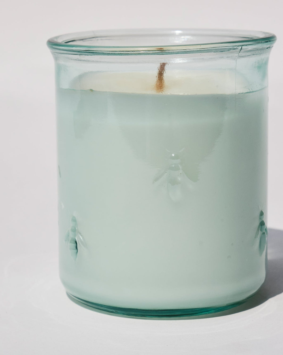 Close-up of Firefly Candle showing embossed bees on the glass side.