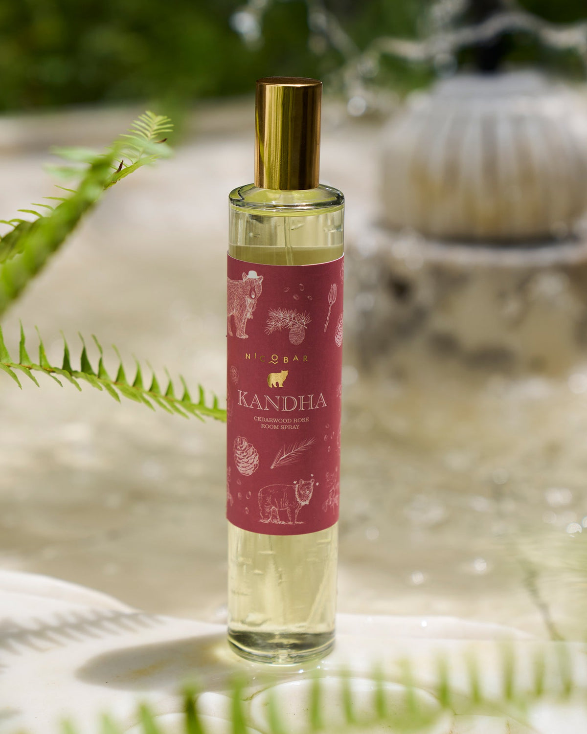 Clear Kandha room spray bottle with maroon label and gold cap.