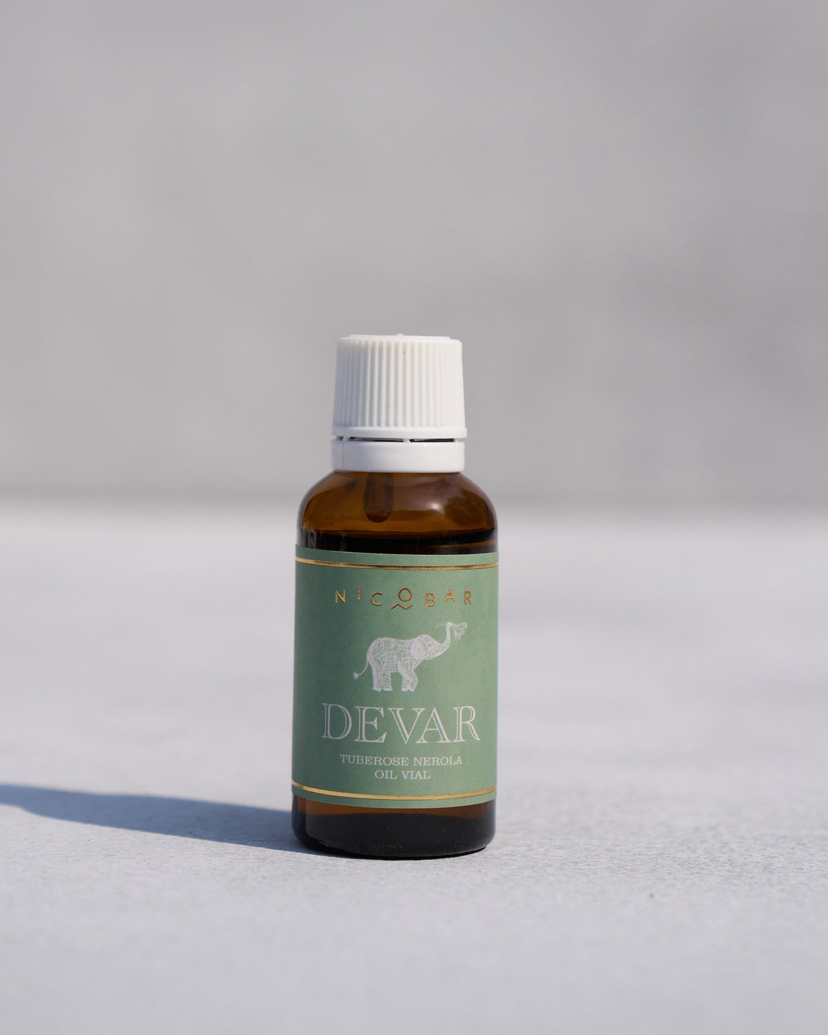 Devar oil vial with an amber glass bottle and white cap.