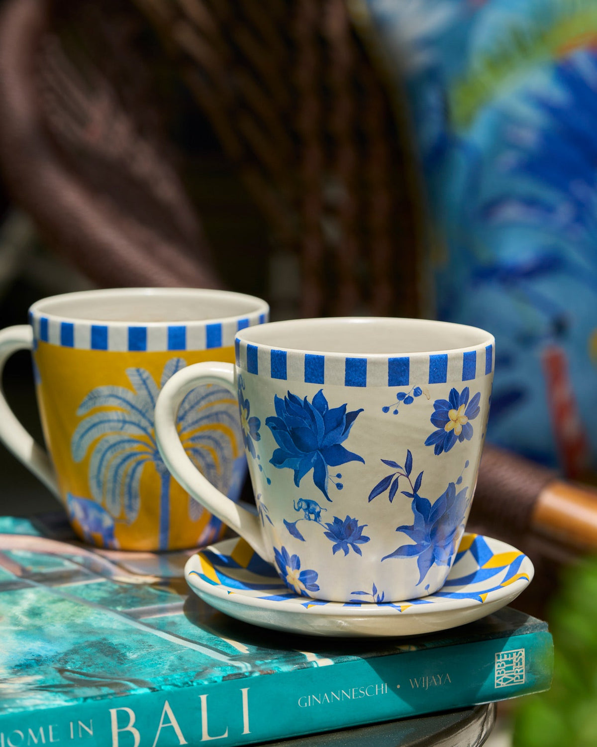 Cream and yellow Panas conical mugs with blue elephant and palm motifs.