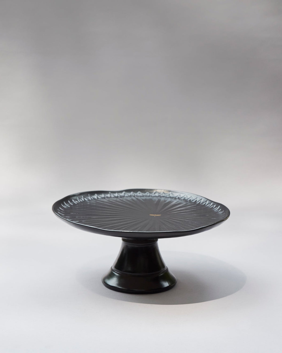 Side view of the black Dragonfly cake stand with its footed base.
