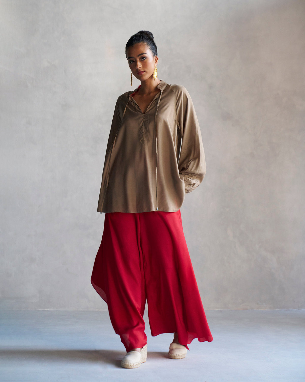 Person wearing an oak brown raglan blouse with loose sleeves.