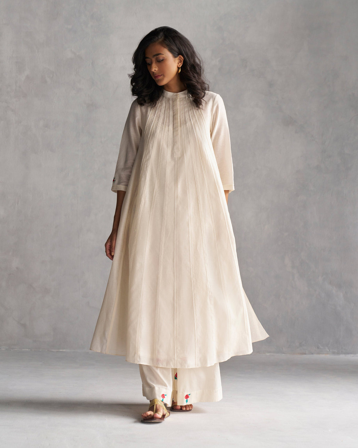 Person wearing Pattaya Kurta with Slip in ivory with pleats down the front.