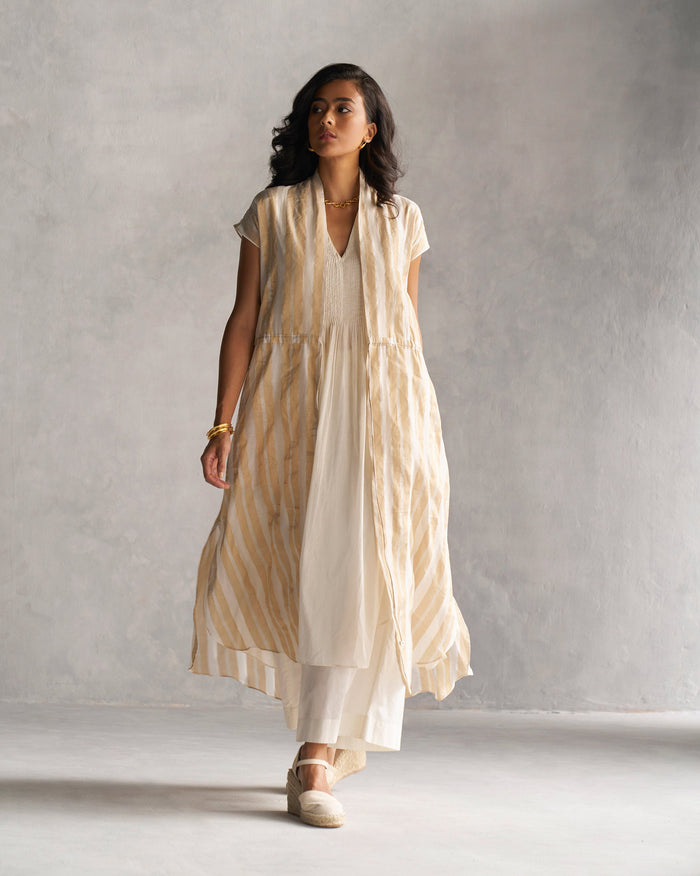 Person wearing a Myra overlay in gold and ivory stripes.